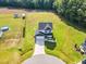 An aerial view showcases a two-story home with a long driveway, spacious lawns, and a well-manicured landscape at 97 Arapahoe Dr, Kenly, NC 27542