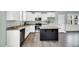Kitchen displays stainless steel appliances, white cabinets, granite countertops and a dark central island at 97 Arapahoe Dr, Kenly, NC 27542