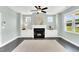 Bright living room features a fireplace with built-ins, a ceiling fan, and large windows at 97 Arapahoe Dr, Kenly, NC 27542