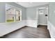 Bright living area featuring large windows, neutral paint, trim, and hardwood floors at 97 Arapahoe Dr, Kenly, NC 27542