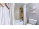 Stylish bathroom with a shower-tub, patterned wallpaper, and sleek shelving for storage at 973 Rebecca Ln, Siler City, NC 27344