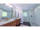 Stylish bathroom featuring dual sinks, modern fixtures, patterned tile and a glass-enclosed shower at 973 Rebecca Ln, Siler City, NC 27344