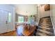 Stylish dining area with hardwood floors, decorative wallpaper, and an elegant white staircase at 973 Rebecca Ln, Siler City, NC 27344