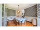 Bright dining room features hardwood floors, unique wallpaper and a modern white table at 973 Rebecca Ln, Siler City, NC 27344
