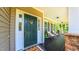 Inviting front porch with a green front door, stone accents, and comfortable seating at 973 Rebecca Ln, Siler City, NC 27344