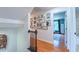 Upstairs hallway with hardwood floors, decorative wall art, and a door leading to a bedroom at 973 Rebecca Ln, Siler City, NC 27344