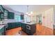 Bright kitchen offers green cabinets, white countertops, stainless appliances, and an island that opens to the living room at 973 Rebecca Ln, Siler City, NC 27344