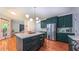 Kitchen featuring green cabinets, quartz countertops, stainless steel appliances, and a modern light fixture at 973 Rebecca Ln, Siler City, NC 27344