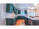 A bright kitchen showcases green cabinets, stainless steel appliances, white quartz countertops, and hardwood floors at 973 Rebecca Ln, Siler City, NC 27344