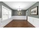 Elegant dining room features wainscoting, wood floors, a chandelier, and bright windows at 1001 N Orange Ave, Dunn, NC 28334