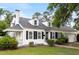 Charming home with a manicured lawn, classic white facade, black shutters, and a welcoming front porch at 1001 N Orange Ave, Dunn, NC 28334