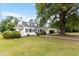 Exterior view of charming home with manicured lawn and mature tree at 1001 N Orange Ave, Dunn, NC 28334