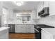 Bright kitchen features white cabinetry, modern stainless steel appliances, and wood flooring at 1001 N Orange Ave, Dunn, NC 28334