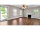 Inviting living room boasts wood floors, a decorative fireplace, and natural light from large windows and glass door at 1001 N Orange Ave, Dunn, NC 28334