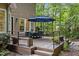 Inviting back deck with an outdoor dining set, seating, and a beautiful view of the lush, wooded backyard at 1004 Staffield Lane Ln, Chapel Hill, NC 27516