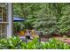 A view of the back deck and fire pit with outdoor seating, surrounded by beautiful greenery at 1004 Staffield Lane Ln, Chapel Hill, NC 27516