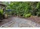 Stone path leading to a back deck and fire pit area, enveloped by a serene wooded setting at 1004 Staffield Lane Ln, Chapel Hill, NC 27516