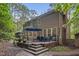 Exterior view of a home with a back deck, fire pit, and a well-maintained yard in a serene wooded setting at 1004 Staffield Lane Ln, Chapel Hill, NC 27516