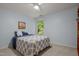 Light blue painted bedroom with ceiling fan, large window and closet at 1004 Staffield Lane Ln, Chapel Hill, NC 27516