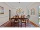 Formal dining room showcasing wood table with chandelier, patterned rug, and bright windows at 1004 Staffield Lane Ln, Chapel Hill, NC 27516