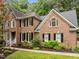 Traditional brick home featuring manicured landscaping and black window shutters at 1004 Staffield Lane Ln, Chapel Hill, NC 27516