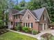 A brick and siding home has an attached two-car garage and well-maintained landscaping at 1004 Staffield Lane Ln, Chapel Hill, NC 27516