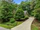 Beautiful exterior view of a well-manicured yard and a long driveway leading up to a charming two-story home at 1004 Staffield Lane Ln, Chapel Hill, NC 27516