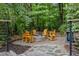 A fire pit area with plenty of outdoor seating surrounded by a wooded landscape at 1004 Staffield Lane Ln, Chapel Hill, NC 27516