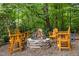 Stone fire pit with wooden chairs, surrounded by beautiful greenery, perfect for relaxing and entertaining outdoors at 1004 Staffield Lane Ln, Chapel Hill, NC 27516