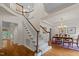 Bright foyer features a staircase with carpet runner, wood floors, and views into dining area at 1004 Staffield Lane Ln, Chapel Hill, NC 27516