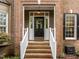 Inviting front door with decorative wreath and sidelights, set in brick facade at 1004 Staffield Lane Ln, Chapel Hill, NC 27516