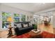 Comfortable living room featuring a black sofa, area rug, hardwood floors and views to the backyard at 1004 Staffield Lane Ln, Chapel Hill, NC 27516