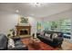 Cozy living room with brick fireplace, hardwood floors and large windows offering natural light at 1004 Staffield Lane Ln, Chapel Hill, NC 27516