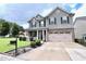 Inviting two-story home featuring gray siding, black shutters, and a well-manicured lawn at 101 Claystone Dr, Gibsonville, NC 27249