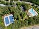 Aerial view of community amenities including a swimming pool, tennis courts, clubhouse, and parking at 105 Spring Bud Dr, Cary, NC 27513
