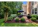 Well-manicured backyard features a patio, grill, seating, green space, and lush landscaping at 105 Spring Bud Dr, Cary, NC 27513