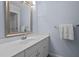 Well-lit bathroom featuring a large mirror, white cabinets, and chrome fixtures at 105 Spring Bud Dr, Cary, NC 27513