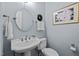 Powder room with pedestal sink, round mirror and floral artwork at 105 Spring Bud Dr, Cary, NC 27513