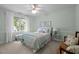 Well-lit bedroom featuring large window, overhead fan, and green and white bedding at 105 Spring Bud Dr, Cary, NC 27513