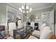 Dining room with a glass table, soft green walls and a decorative chandelier at 105 Spring Bud Dr, Cary, NC 27513