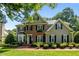 Charming two-story home with brick and siding, black shutters, and a beautifully landscaped front yard at 105 Spring Bud Dr, Cary, NC 27513