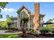 Back of house features tall brick chimney, multiple windows, and a brick patio at 105 Spring Bud Dr, Cary, NC 27513