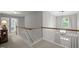 Upstairs hallway featuring a staircase with white railings and a chandelier at 105 Spring Bud Dr, Cary, NC 27513