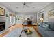 Living room with french doors, plush seating, fireplace, and view into the kitchen at 105 Spring Bud Dr, Cary, NC 27513