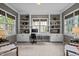 Home office with custom built-in shelving and cabinets, neutral carpet, and large windows at 105 Spring Bud Dr, Cary, NC 27513