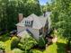 Rear view of a two-story home with a landscaped yard, patio area, and lush greenery at 105 Spring Bud Dr, Cary, NC 27513