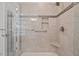 Updated shower featuring decorative tile accents, built in shelves, and a corner seat at 105 Spring Bud Dr, Cary, NC 27513