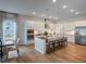 Open kitchen with a large island, stainless steel appliances, and light wood floors at 1107 Masters Place Way # 155, Durham, NC 27703