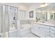 Bright bathroom showcasing a glass shower, soaking tub, and a granite-topped vanity with ample white cabinetry at 112 Filigree Way, Durham, NC 27713