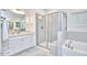 Bright bathroom featuring a glass shower, soaking tub, and a granite-topped vanity with white cabinetry at 112 Filigree Way, Durham, NC 27713